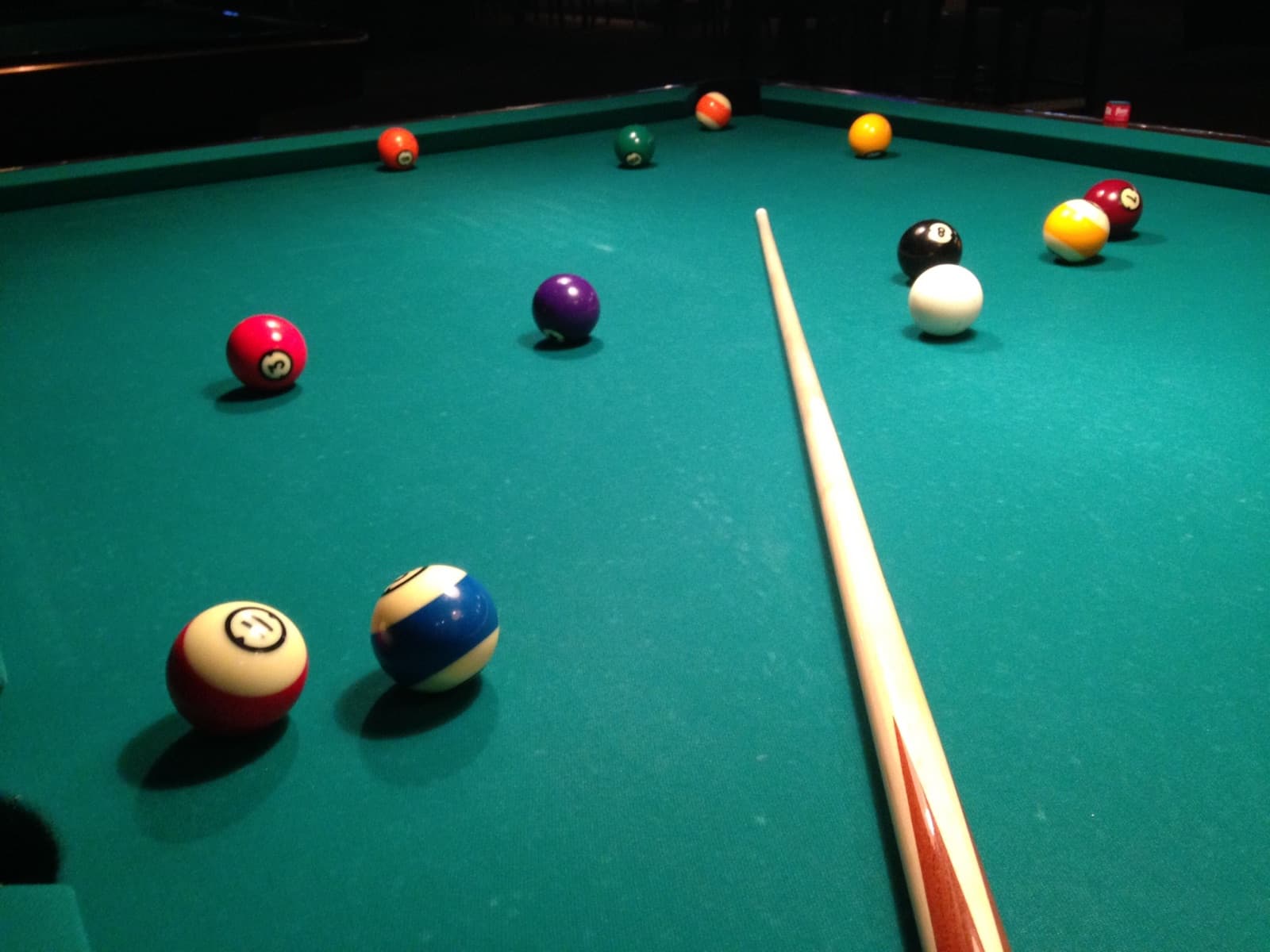 Pool balls and a cue on green felt