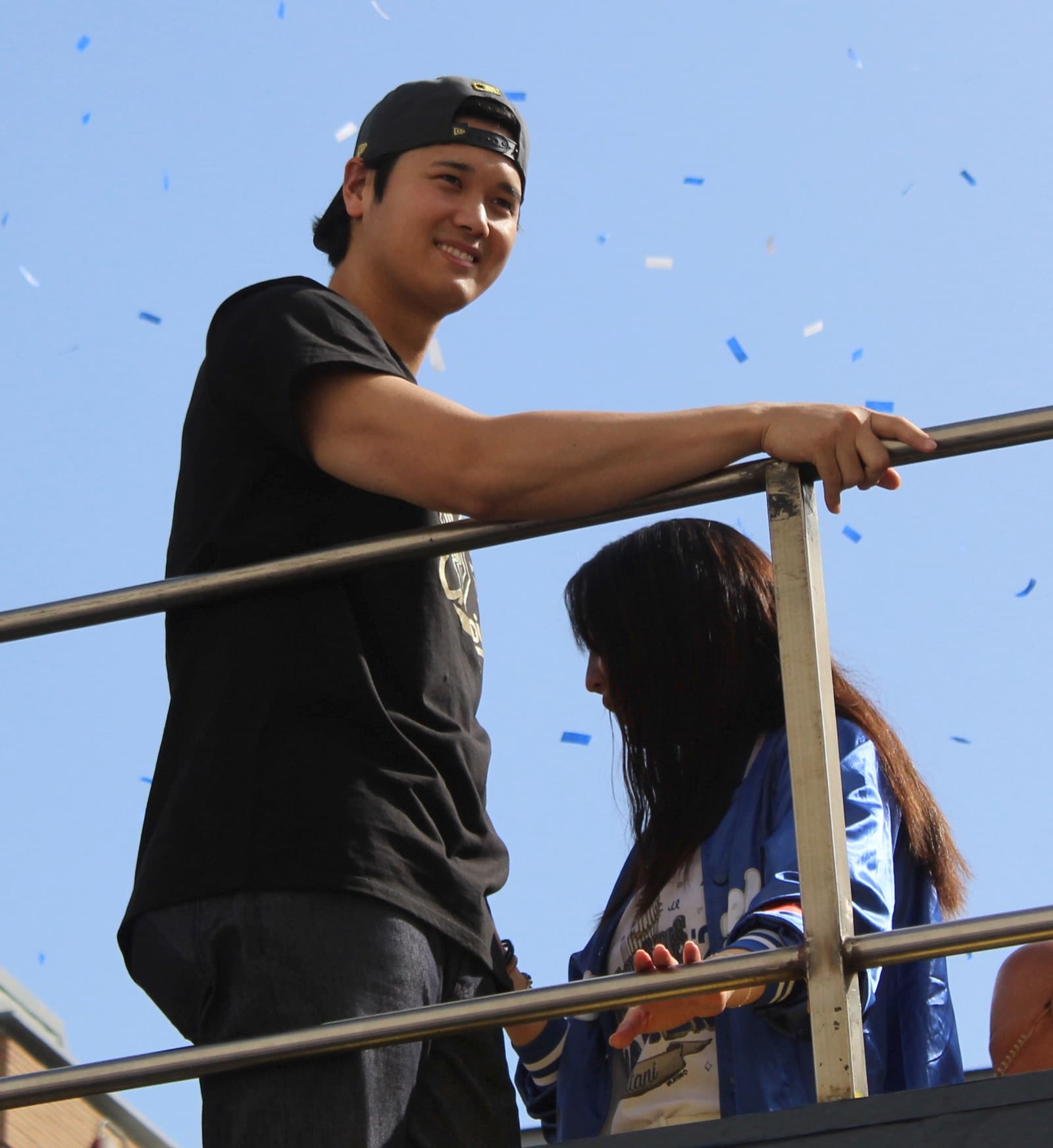 Shohei Ohtani smiling under blue confetti at the Dodgers' 2025 World Series parade